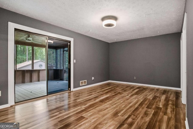 empty room featuring a textured ceiling and hardwood / wood-style floors