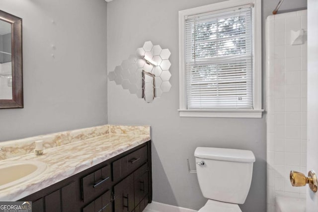 bathroom featuring a shower, vanity, and toilet