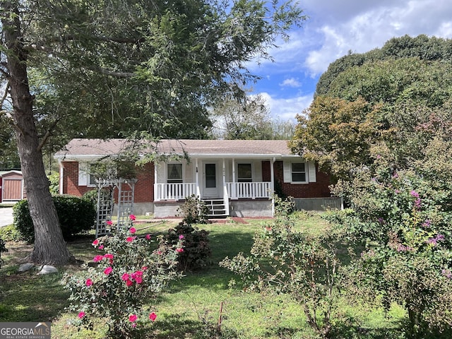 ranch-style home featuring a front yard and covered porch