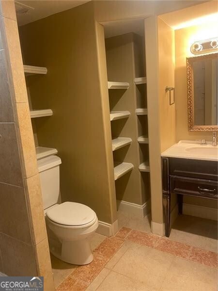 bathroom with vanity, toilet, and tile patterned floors