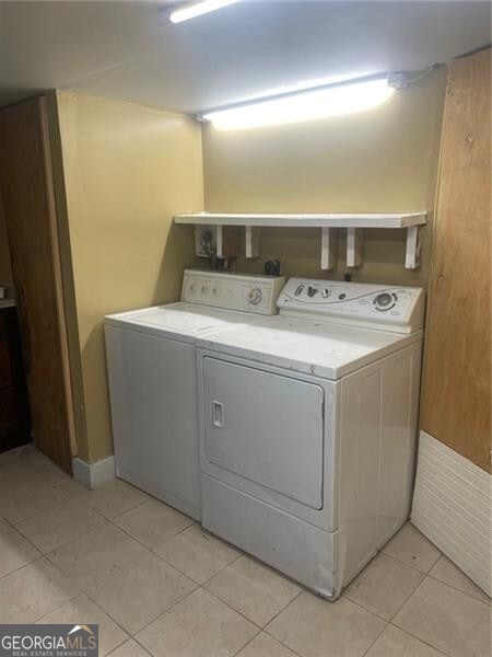 washroom featuring washer and clothes dryer and light tile patterned floors