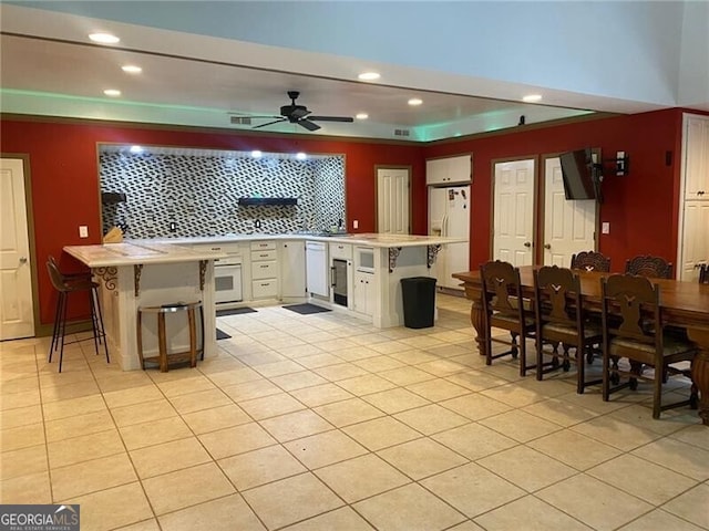 kitchen with ceiling fan, a kitchen breakfast bar, and kitchen peninsula