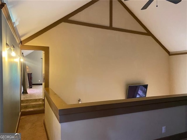 hallway with light carpet and vaulted ceiling