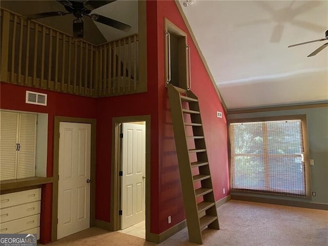 staircase with carpet, vaulted ceiling, and ceiling fan