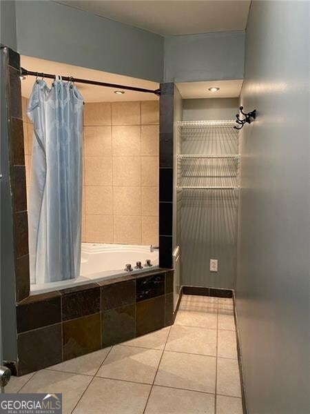 bathroom featuring shower / bathtub combination with curtain and tile patterned floors