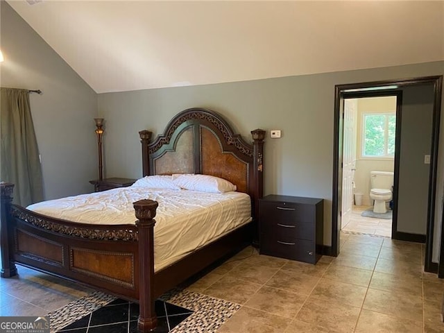 tiled bedroom featuring ensuite bath and vaulted ceiling