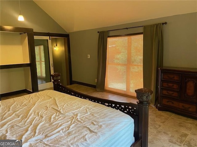 bedroom featuring a barn door and vaulted ceiling