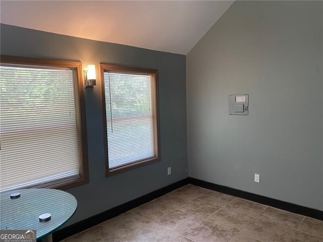 spare room featuring vaulted ceiling and plenty of natural light