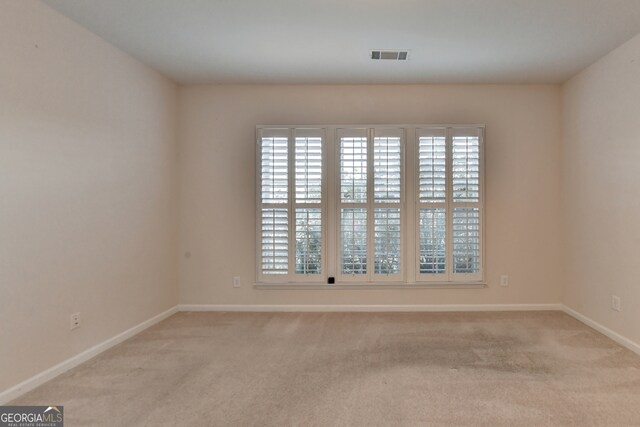 carpeted spare room featuring plenty of natural light