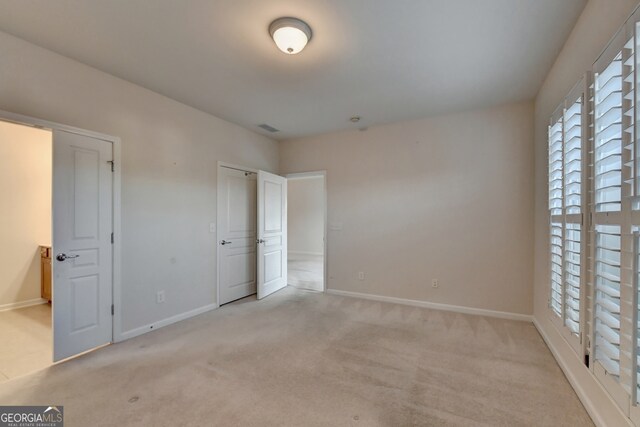 unfurnished bedroom featuring light colored carpet