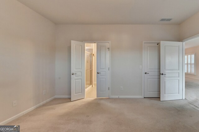 unfurnished bedroom featuring light carpet