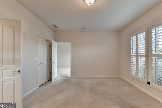 spare room featuring light colored carpet