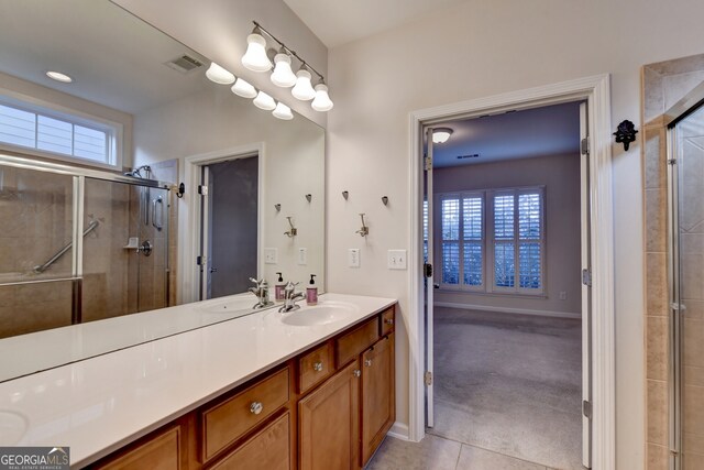 bathroom featuring vanity, tile patterned floors, and a shower with shower door