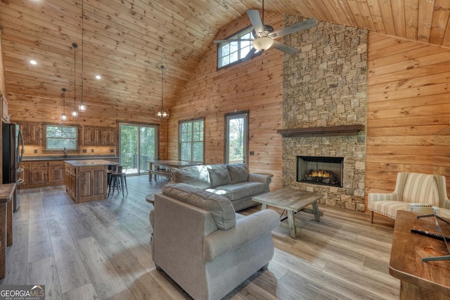 living room featuring light hardwood / wood-style floors, wood ceiling, ceiling fan, and high vaulted ceiling