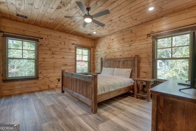 bedroom with light wood-type flooring, wood ceiling, and multiple windows