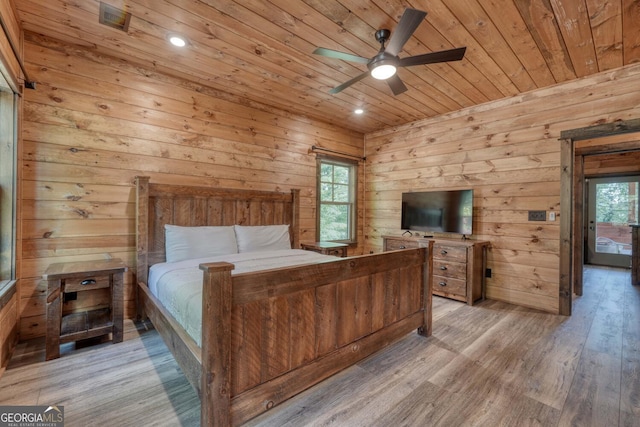 bedroom featuring ceiling fan, wood walls, light hardwood / wood-style floors, and wooden ceiling