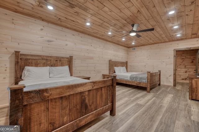 bedroom featuring wood ceiling, light wood-type flooring, wood walls, and ceiling fan