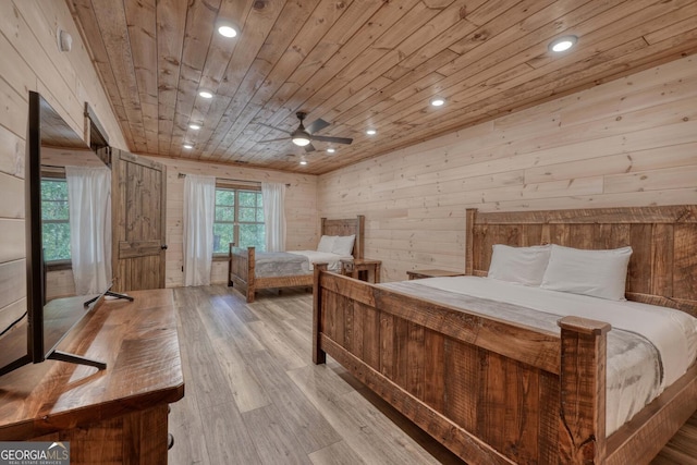 bedroom featuring wood ceiling, wooden walls, and light hardwood / wood-style flooring