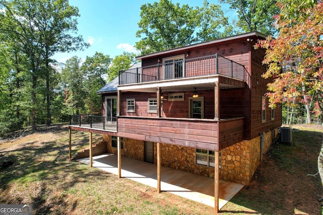 rear view of house with cooling unit and a patio