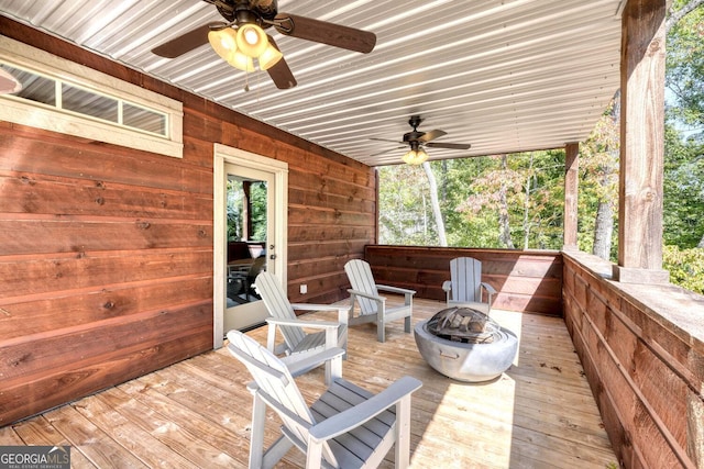 wooden terrace with ceiling fan and a fire pit