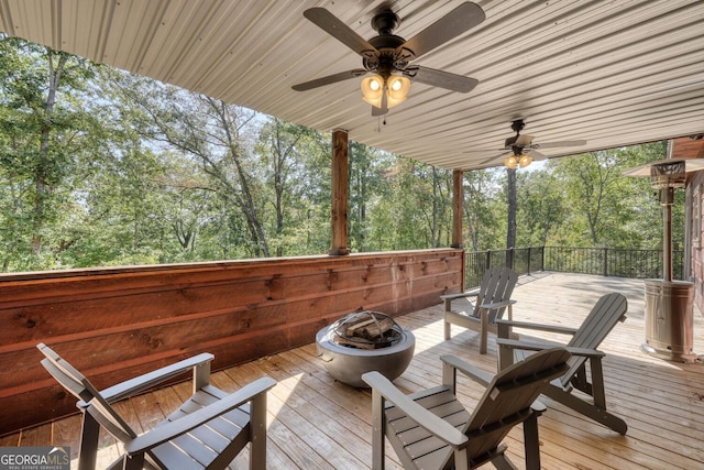 wooden deck featuring ceiling fan and a fire pit