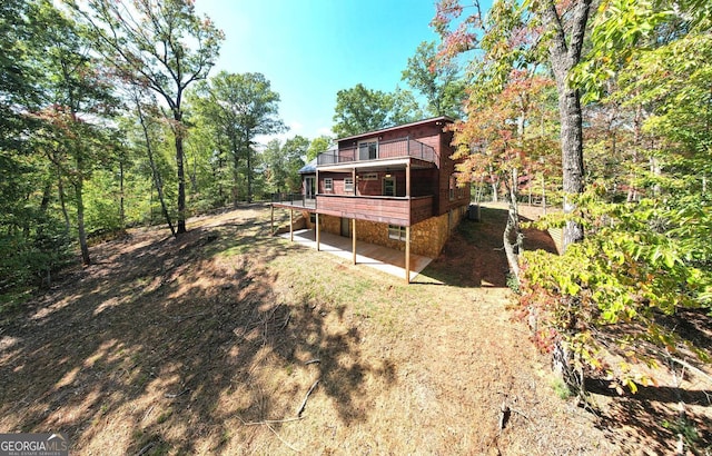 back of property with central AC unit, a deck, and a patio