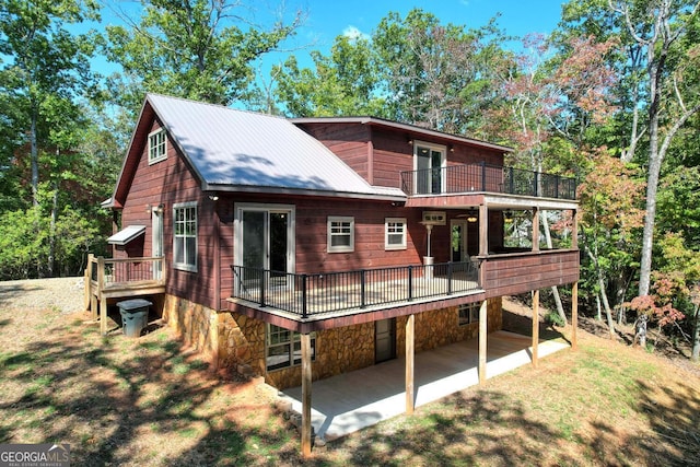 back of property featuring a balcony and a patio