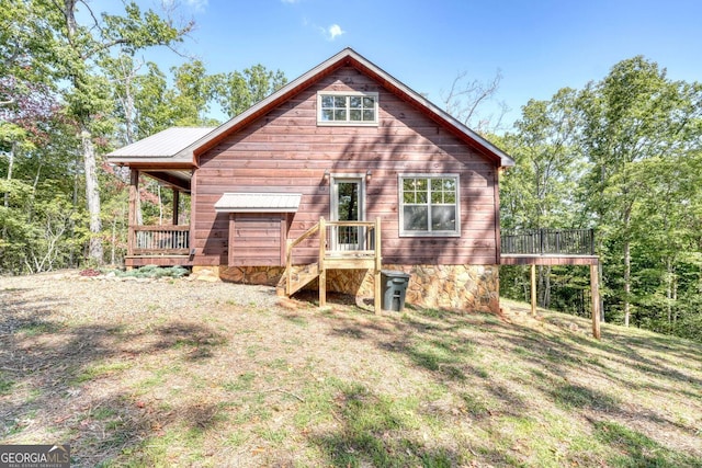 back of property featuring a deck and a yard