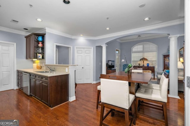 interior space featuring dishwasher, decorative columns, crown molding, and dark hardwood / wood-style flooring