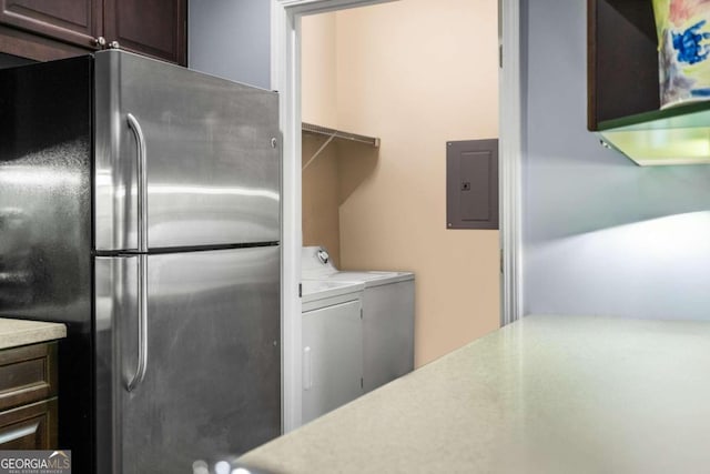 interior space featuring stainless steel refrigerator, dark brown cabinets, electric panel, and washer and clothes dryer