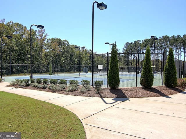 view of sport court with a lawn