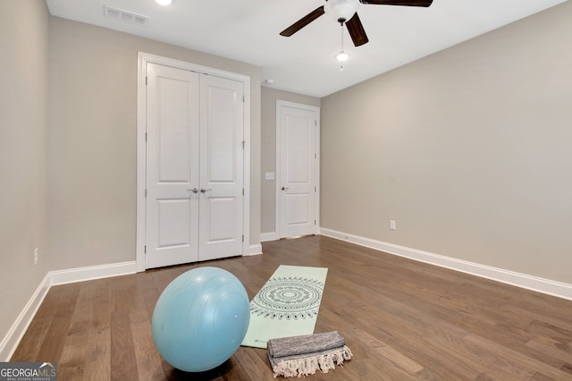 workout area featuring ceiling fan and wood-type flooring