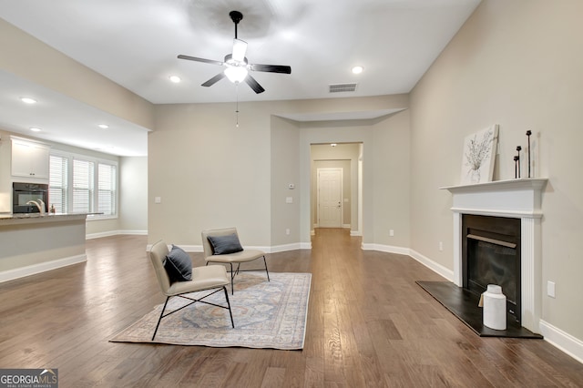 living area with ceiling fan and hardwood / wood-style flooring