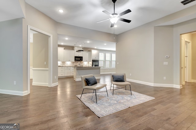 living room with ceiling fan and dark wood-type flooring