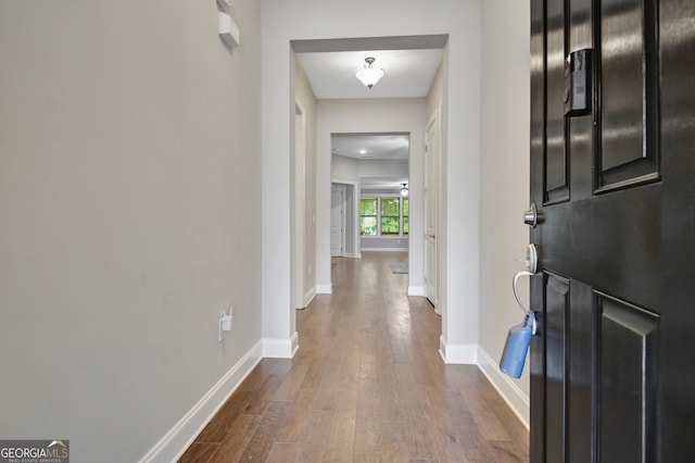 corridor with dark hardwood / wood-style flooring