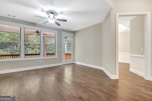 spare room with wood-type flooring, ceiling fan, and a healthy amount of sunlight