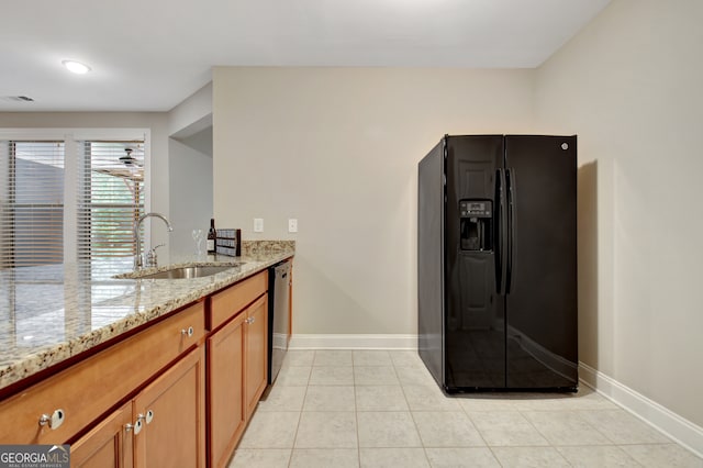 kitchen featuring light stone counters, light tile patterned floors, sink, and black appliances