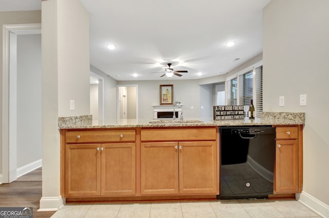 kitchen featuring light tile patterned flooring, light stone counters, black dishwasher, kitchen peninsula, and ceiling fan