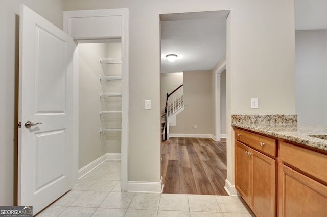 interior space with light stone counters and light hardwood / wood-style flooring