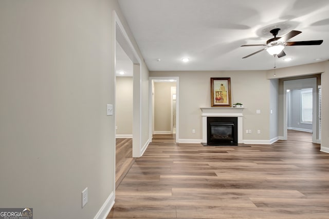 unfurnished living room featuring light hardwood / wood-style floors and ceiling fan