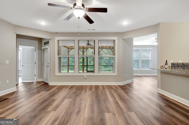 unfurnished living room with wood-type flooring and ceiling fan