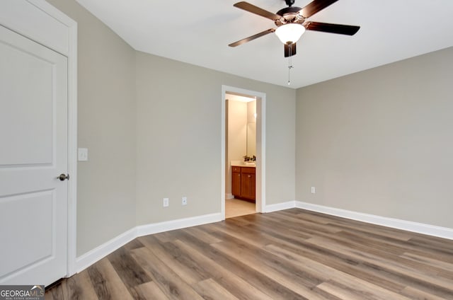 unfurnished bedroom featuring ceiling fan, light wood-type flooring, and connected bathroom