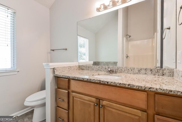 bathroom featuring walk in shower, vanity, toilet, and a healthy amount of sunlight