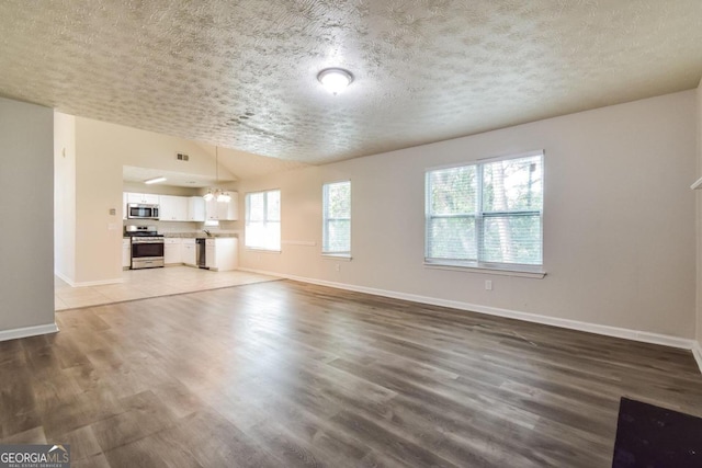 unfurnished living room featuring wood-type flooring and a textured ceiling