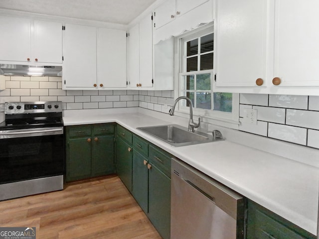 kitchen with light hardwood / wood-style floors, sink, white cabinets, decorative backsplash, and appliances with stainless steel finishes