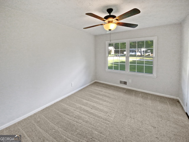 carpeted spare room featuring ceiling fan and a textured ceiling