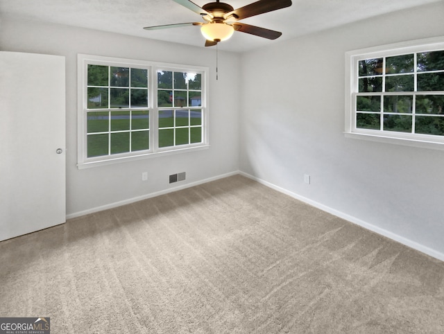 carpeted spare room featuring ceiling fan