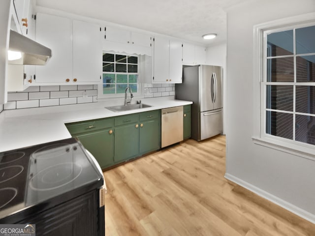 kitchen with appliances with stainless steel finishes, white cabinetry, tasteful backsplash, sink, and green cabinets