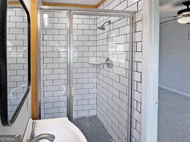 bathroom featuring ceiling fan, walk in shower, and sink