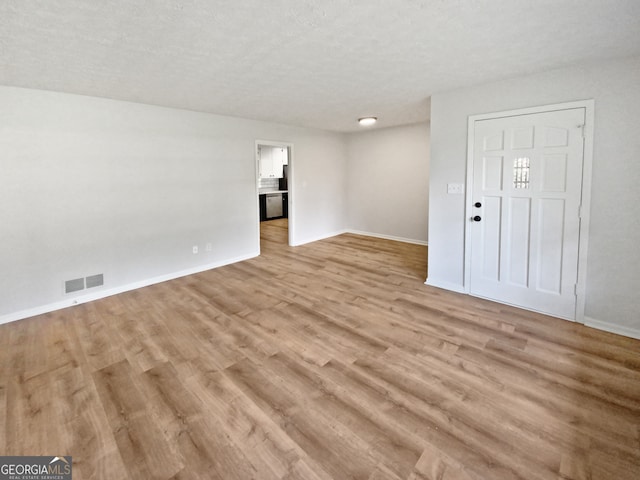 interior space with light hardwood / wood-style flooring and a textured ceiling